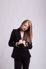 Obraz premium Styled gorgeous woman in fashion suit on gray background in studio photo. Elegant blonde