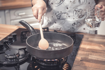 Preparing food in frying pan.