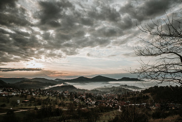 Village in the mountains with clouds and fog and sun in sunset