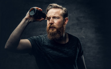 A man looking throught beer bottles.