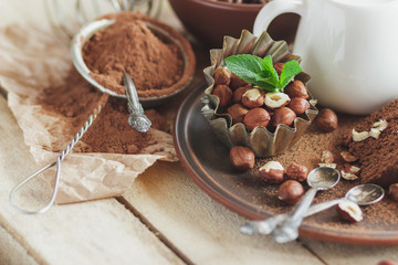 Piece of chocolate cake, mint leaves, hazelnuts and jar with milk