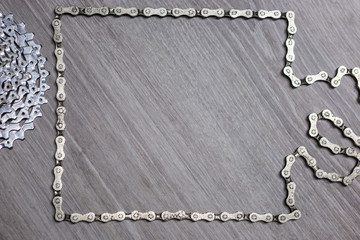 White metal rusty and oily assorted items, bicycle parts like chain and cassette related with bicycle repair on a wooden background with copyspace