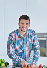 Happy man using digital tablet in kitchen at home