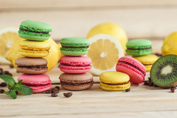 Green, pink, yellow and brown french macarons with lemon and coffee beans