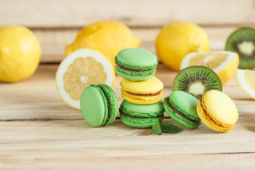 Green and yellow french macarons with kiwi, lemon and mint decorations