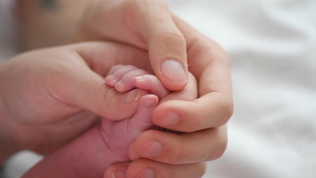 Father and mother holding newborn baby hand. 4K UHD video 3840X2160