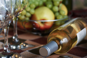 Wine glasses and a bottle of wine on a background of fruit