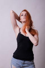 Fototapeta premium Sexy busty redheand woman in studio photo on gray background. Sexuality and sensuality. Attractive model