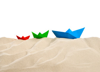 On the Beach - Sand dune with three colorful paper boats in front of a white background - clipping...