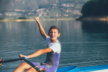 A Young single scull rowing competitor paddles on the tranquil lake © FS-Stock