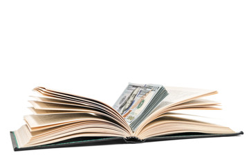 Open book with a stack of dollars lying in it, isolated on a white background