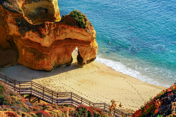beautiful Atlantic ocean view horizon with sandy beach,  rocks and waves. Algarve,  Portugal