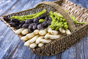 Frischer weißer, grüner und lila Spargel  als close-up in einem Korb