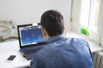 young man with laptop in the room working or studying