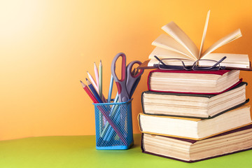 Open book, hardback books on bright colorful background.