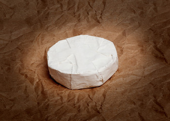 Fresh Camembert cheese is a natural, on Kraft paper
