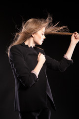 Beautiful sexy blonde model posing in fashion style on black background in studio photo. Glamour and elegance