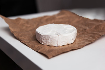 Fresh Camembert cheese is a natural, on Kraft paper