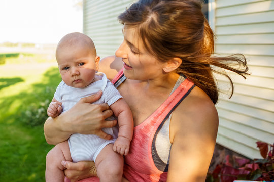 Happy mother holding her baby outdoors