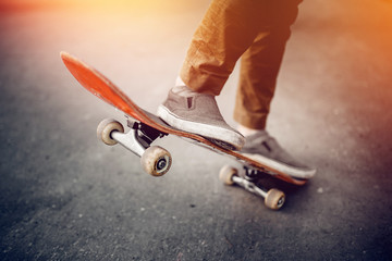 Close-up of a male guy on a skateboard doing trick kicks in shoes. The concept of doing street...
