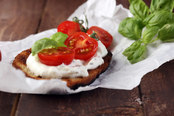 Bread with cream cheese and tomato for lunch table. Sharing antipasti on party or summer picnic...