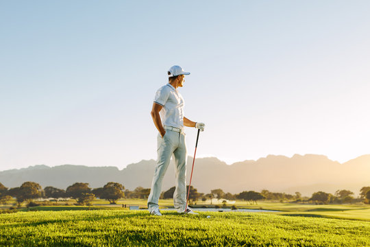 Male golfer standing on golf course - Powered by Adobe
