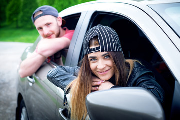 Happy couple in a car. Travel lifestyle. Smiling people. 