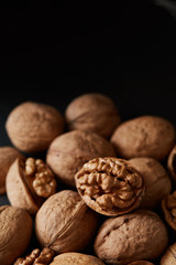 Walnuts and kernels on a black backdrop