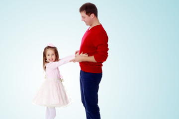 Little girl pulls her hands to his daddy.