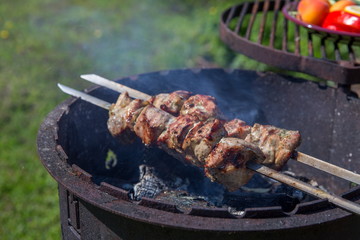 Marinated shashlik preparing on a barbecue grill over charcoal.