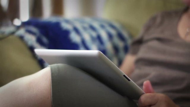 Woman frustrated  at tablet that isn't working in living room