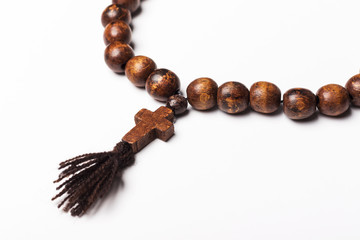Rosary and a cross on a light gray background. 