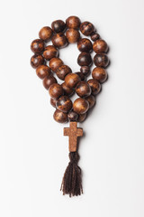 Rosary and a cross on a light gray background. 
