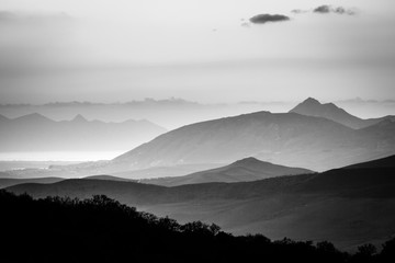 Czarno-biały panoramiczny widok mglisty krajobraz górski i sylwetki. Ficuzza, Sycylia, Włochy - 154786277