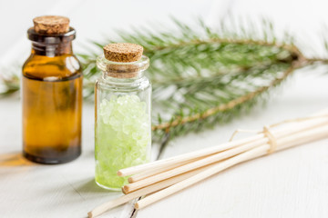 fir branches and spruce bath salt and aroma oil on white table background