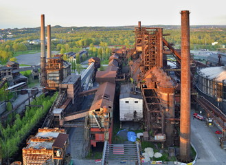 Abandoned ironworks factory with forest in the background