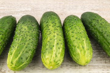 Cucumber on white wooden background close up.