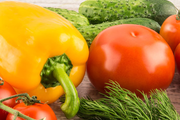 Cucumber, tomato, pepper and fennel on a white wooden background close up.