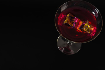 Colorful drink in a cocktail glass, with ice cubes, summer drink