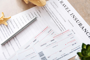 Tickets and pen on travel insurance form