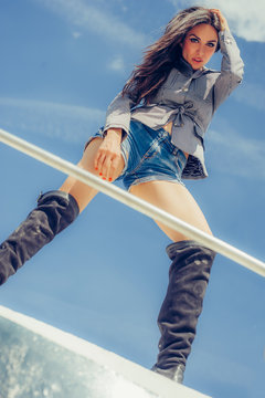 Hot Seductive Woman In Sexy High Black Boots Posing On Boat