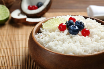 Coconut rice with berries and lime slice on bamboo mat