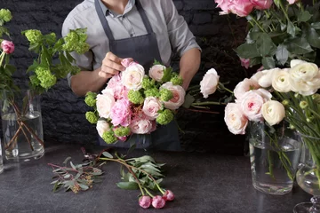 Cercles muraux Fleuriste Male florist creating beautiful bouquet in flower shop, close up