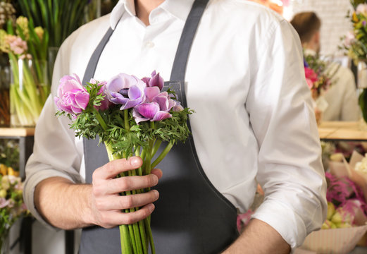 Young florist with beautiful bouquet at flower shop, close up