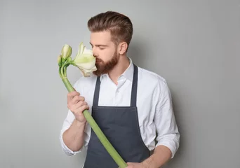 Crédence de cuisine en verre imprimé Fleuriste Young florist with beautiful flower on grey background