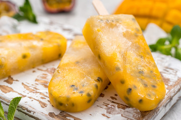 Homemade frozen popsicles with fresh mango and passion fruit