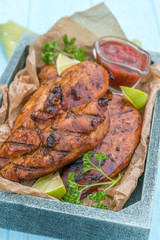 Grilled chicken breast served with herbs and lime