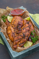 Grilled chicken breast served with herbs and lime