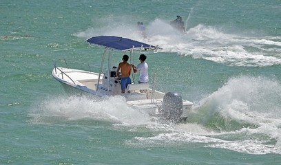 Obraz premium Fishing boat and jet skiers,week-end boat traffic on the florida intra-coastal waterway near miami beach.