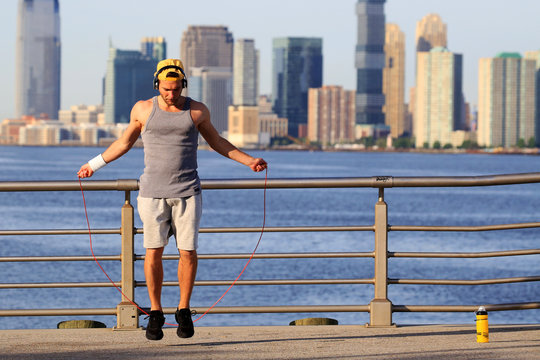 Morning exercises with skipping rope on the background of the city